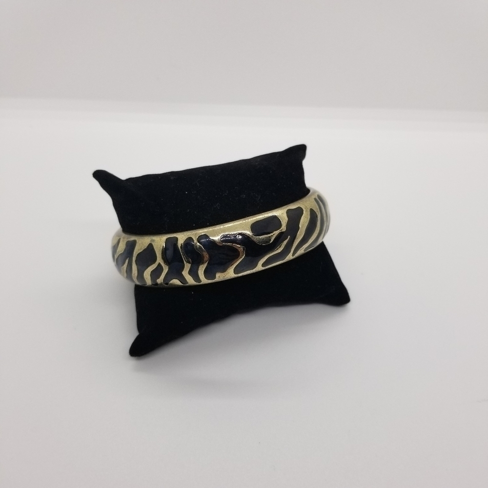 gold tone bangle with abstract black enamel pattern